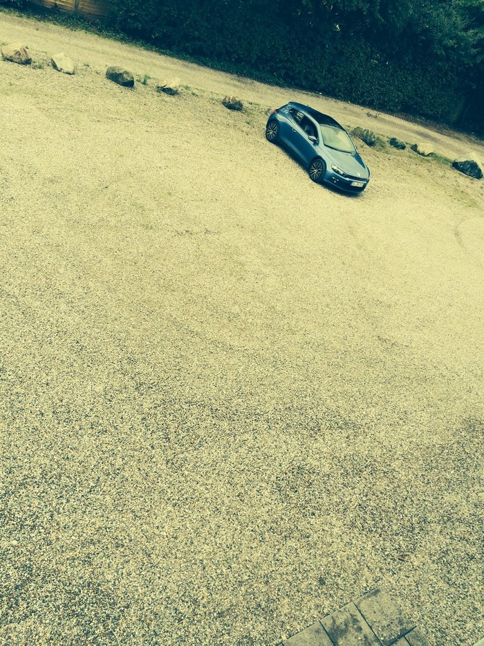 Blue Volkswagen Scirocco parked on a gravel lot