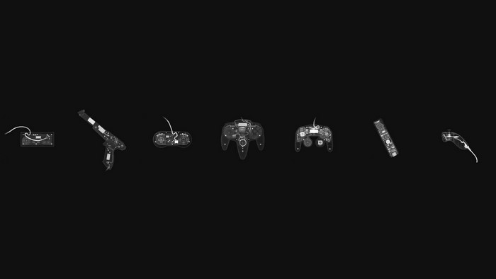 X-ray images of video game controllers on black background