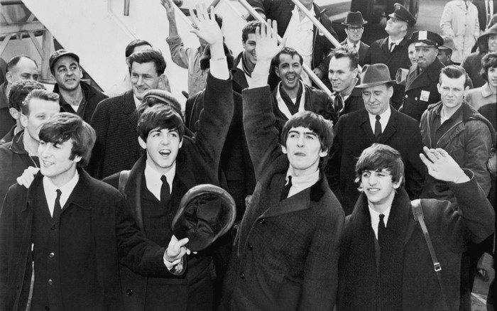 The Beatles arriving at an airport