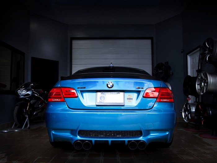 Blue BMW M3 Convertible in Garage with Motorcycle and Rims