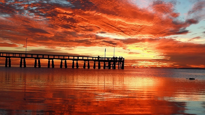 Sunset over a pier with fiery clouds