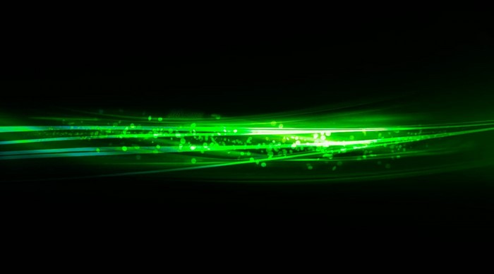 Abstract green light streaks and particles on black background