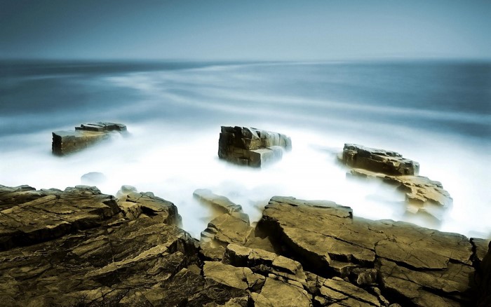 Rocks in the ocean with misty water