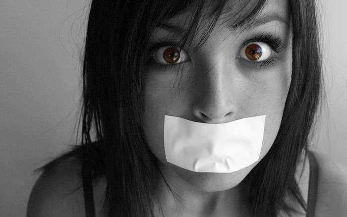 Close up of a woman with tape over her mouth