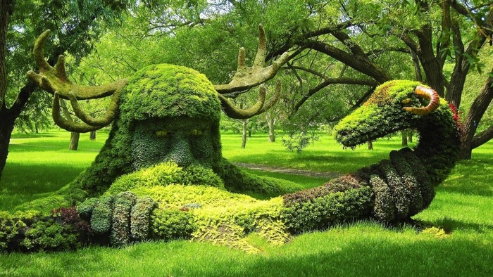 Topiary sculptures of a mythical creature and a dragon in a garden