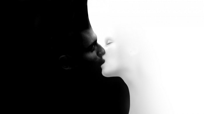 Man and mannequin kissing in black and white