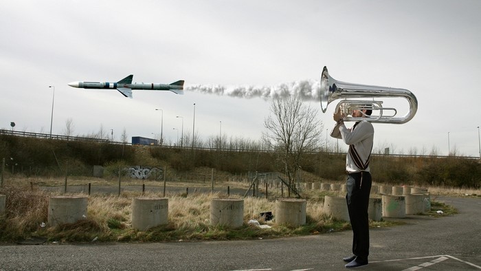 Man playing tuba with rocket launching from it