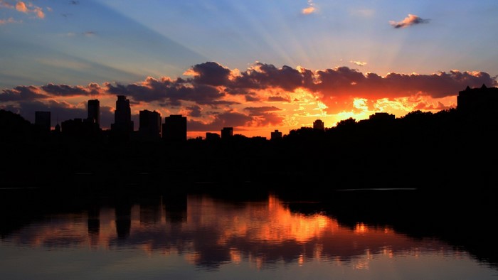 City skyline silhouette at sunset over water