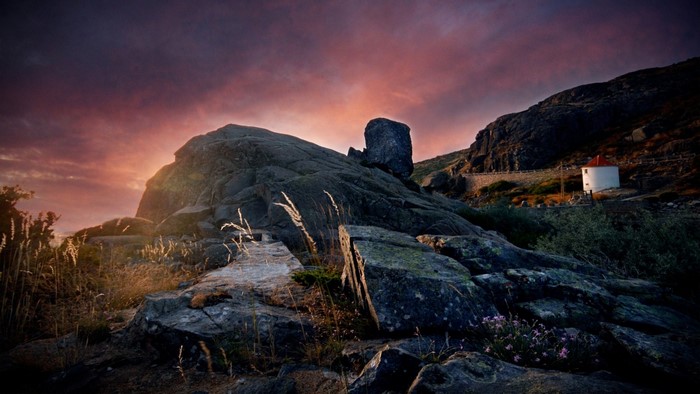Rocky mountain landscape at sunset with a windmill