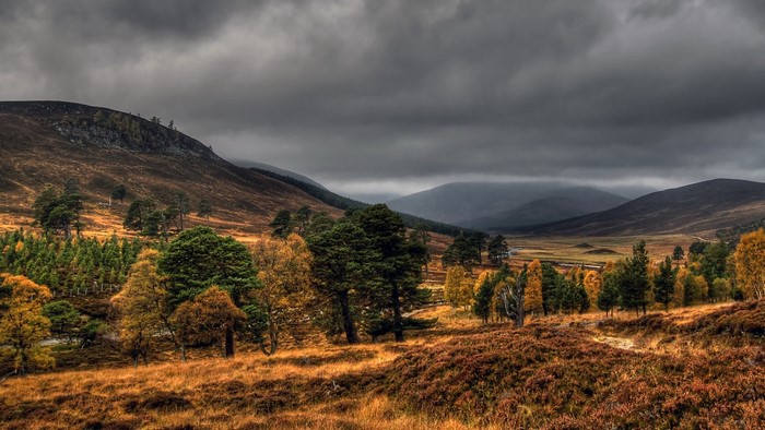 Autumn valley with rolling hills and dark clouds
