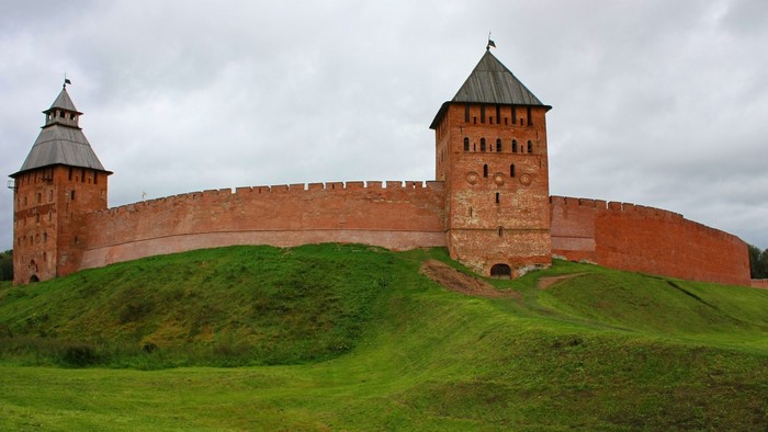 Brick fortress with towers on a grassy hill