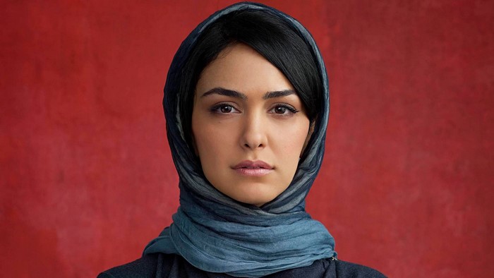 Nazanin Boniadi wearing a headscarf against a red background
