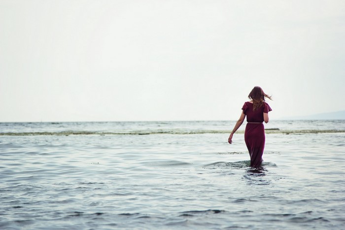 Woman in a dress walking in the sea