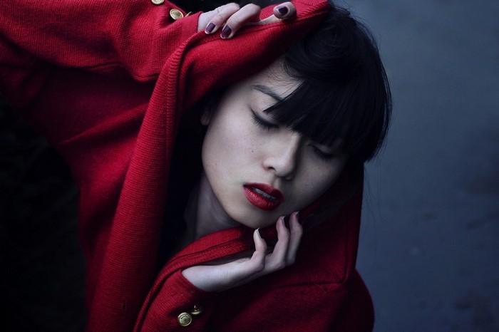 Woman in red sweater with eyes closed