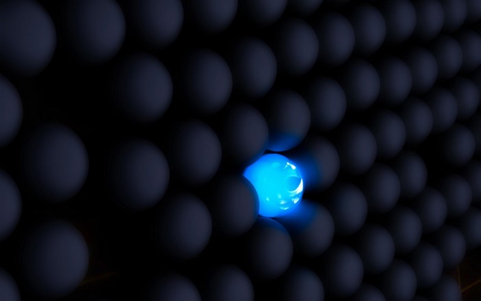 Glowing blue sphere among dark spheres