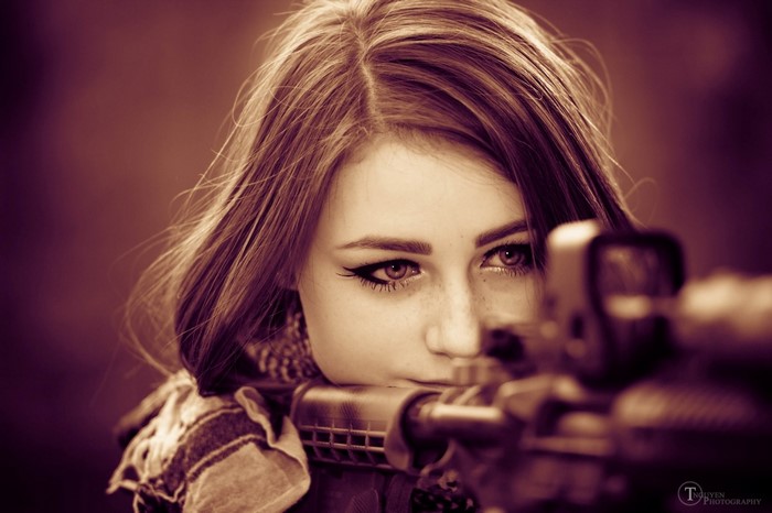 Woman aiming a rifle with a scope