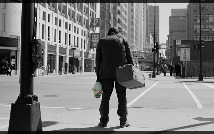 The Joker from The Dark Knight holding a mask