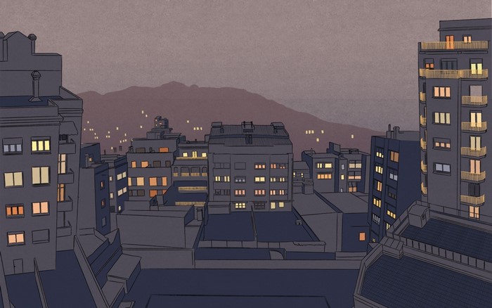 Cityscape at dusk with illuminated buildings and mountains