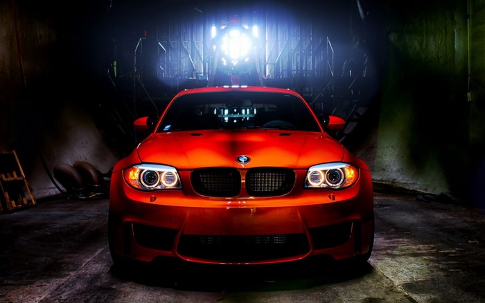 Red BMW 1 Series Coupe in a dimly lit garage
