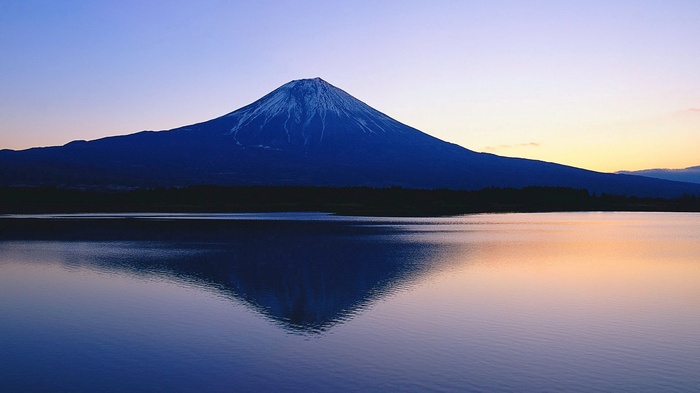 Mount Fuji reflected in a lake at dusk