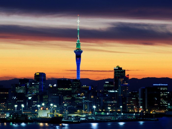 Auckland Sky Tower cityscape at sunset with harbor lights