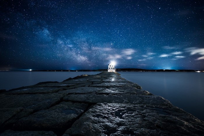 Lighthouse on a pier under the Milky Way