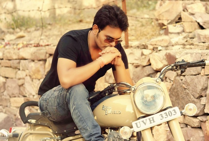 Man in black t-shirt and jeans on a Royal Enfield motorcycle