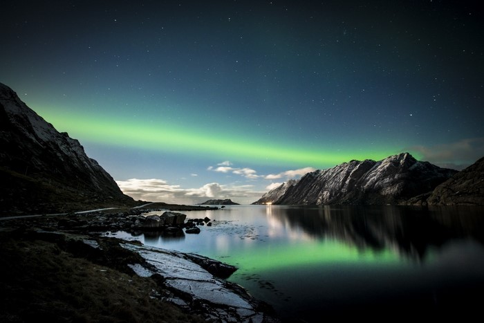 Aurora Borealis over mountains and lake in Lofoten, Norway