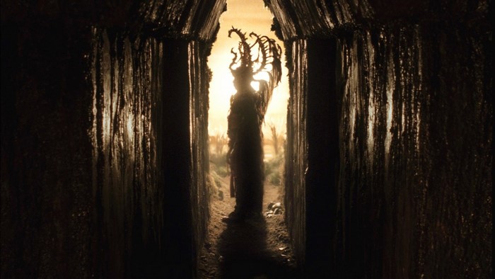 Figure with crown in a dark passage