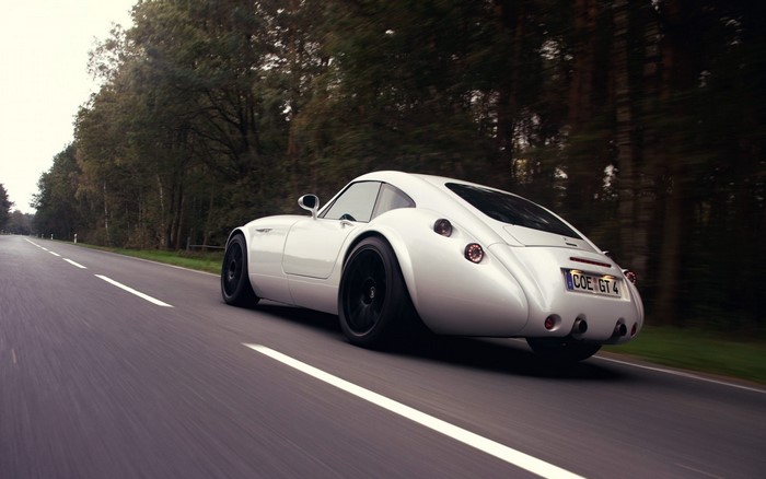 White sports car driving on a road