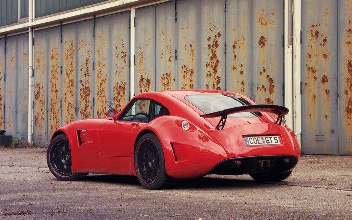Red sports car with spoiler parked outdoors