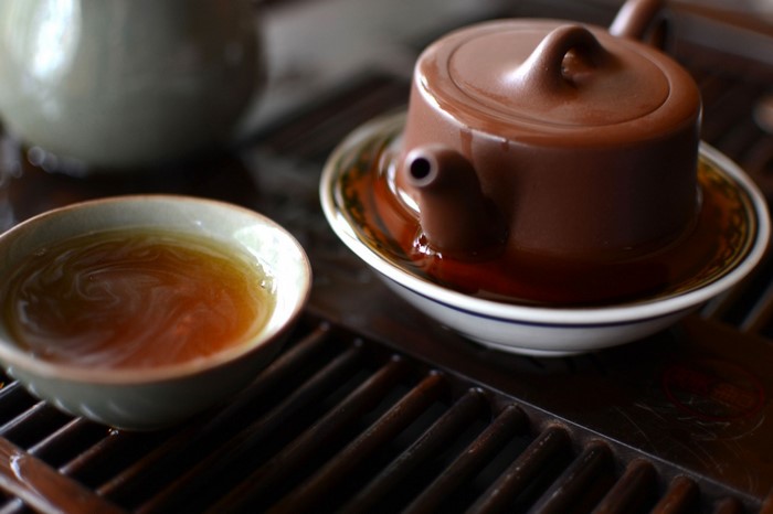 Brown teapot and tea cup on a wooden tray