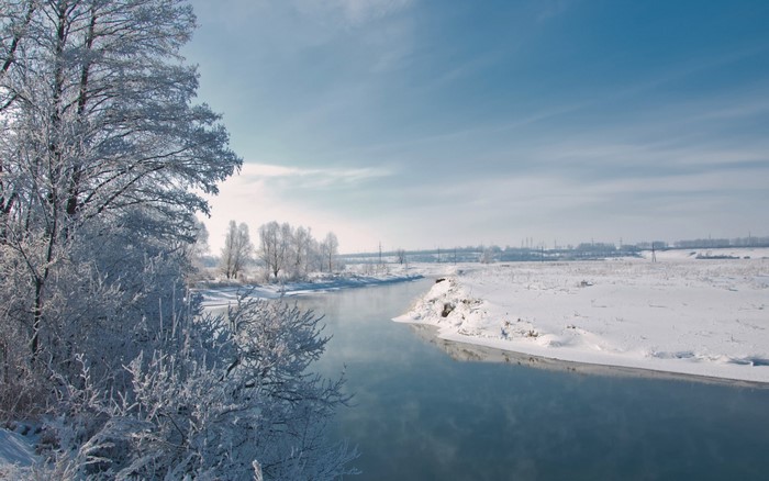 Winter landscape with a river and frost-covered trees