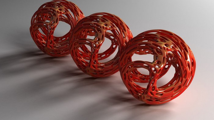 Three abstract red torus shapes on a gray surface