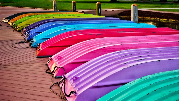 Colorful boats lined up on a wooden dock