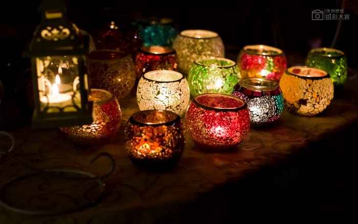 Mosaic candle holders and lantern with lit candles