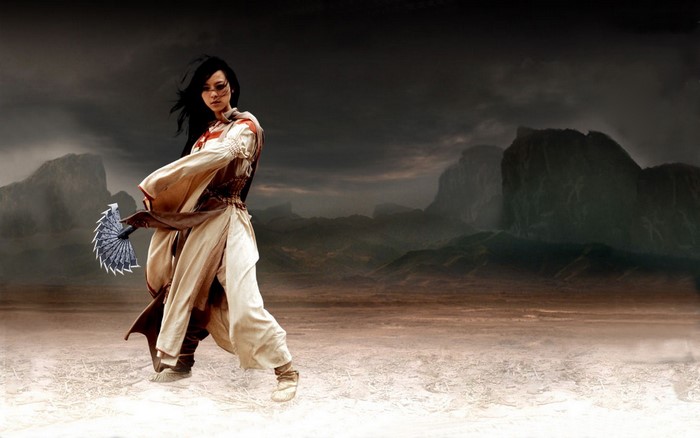 Woman with fan in a desolate landscape