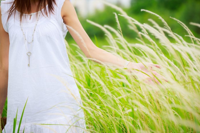 Woman in white dress in a field of tall grass