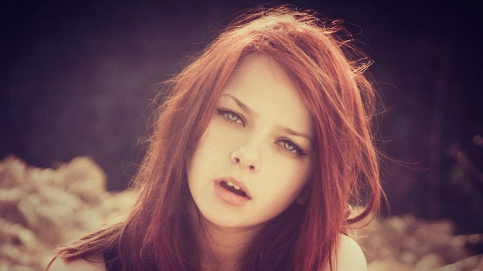 Portrait of a young woman with red hair and blue eyes