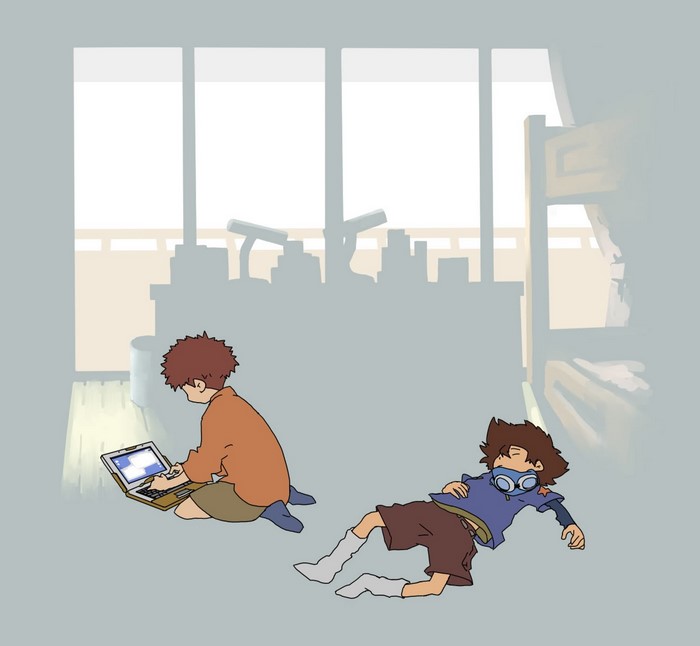 Two boys in a room, one using a laptop