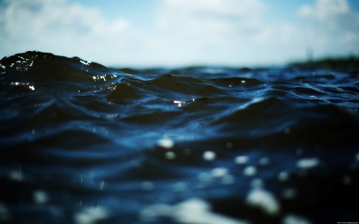Close-up of dark blue ocean waves with sunlight reflections