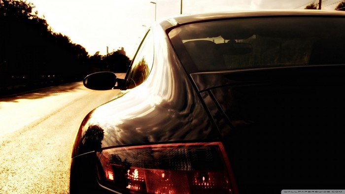 Black Porsche car on a road at dusk