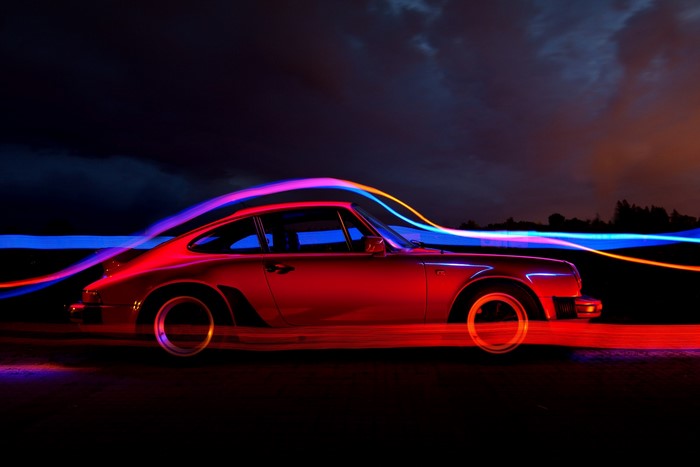 Red Porsche 911 with light trails at night