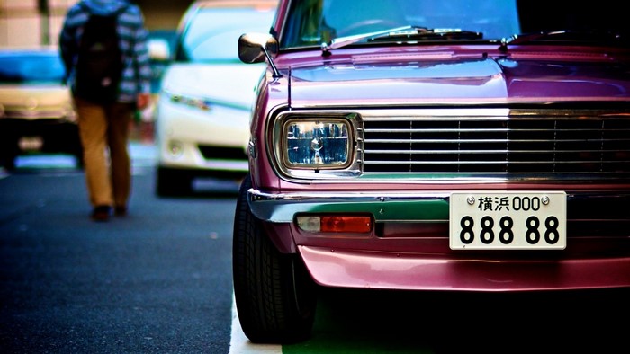 Close-up of a vintage Datsun car with Japanese license plate