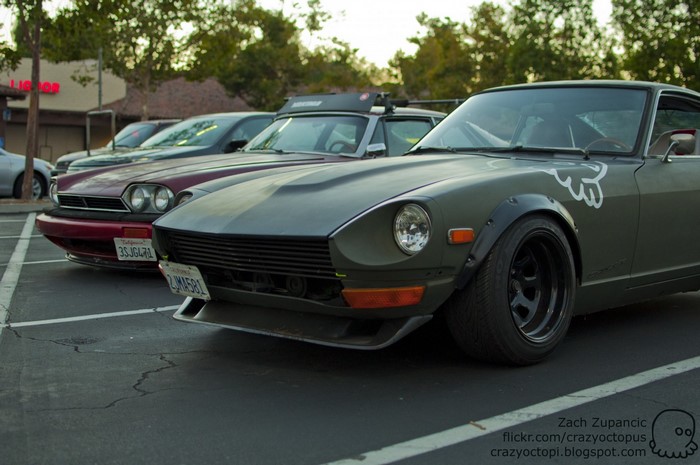 Several cars parked in a lot, including a Datsun Z