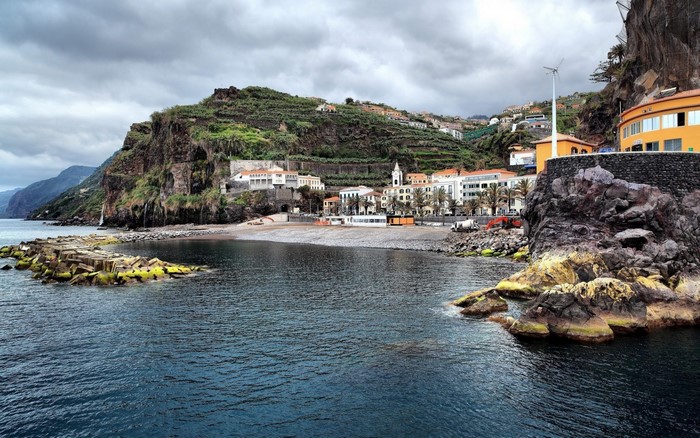 Coastal town with terraced hills and a rocky shore
