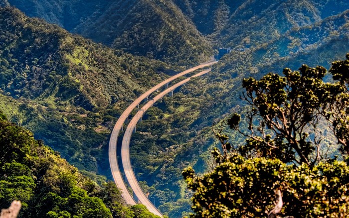 Highway through a lush green mountain valley on Oahu, Hawaii