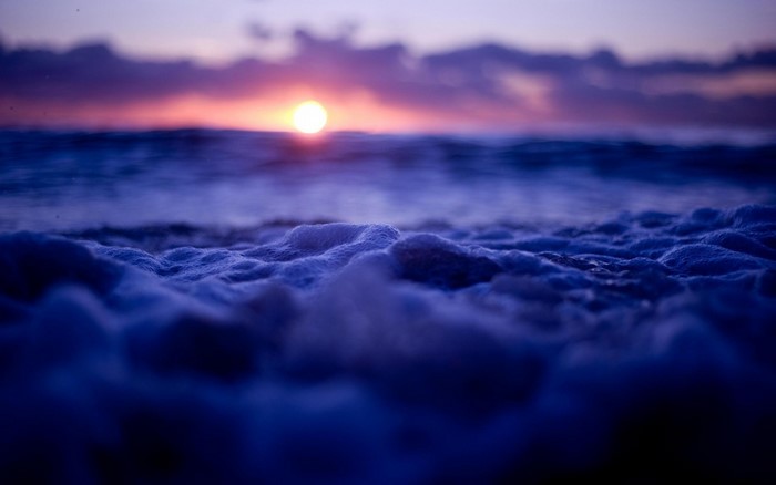 Sunset over the ocean with sea foam