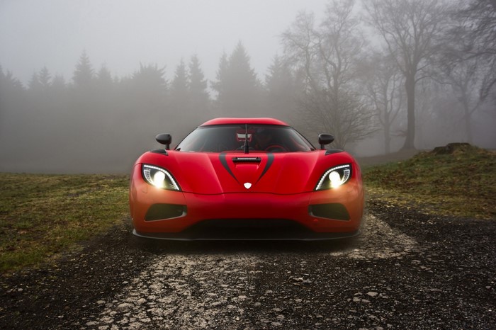 Red Koenigsegg Agera sports car in a foggy forest