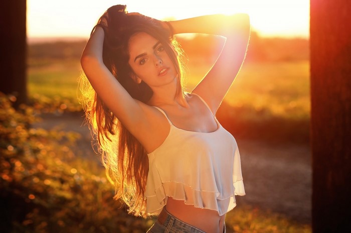 Sunlit Woman in White Tank Top Outdoors